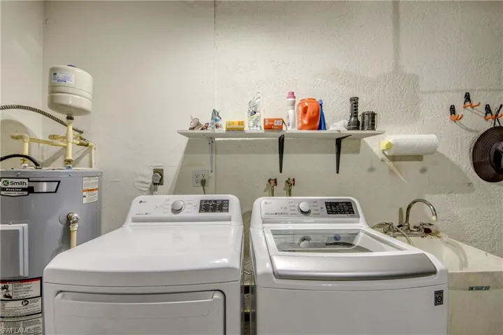 Laundry area featuring electric water heater and independent washer and dryer