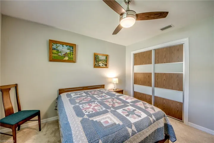 Bedroom featuring a closet, ceiling fan, and light carpet