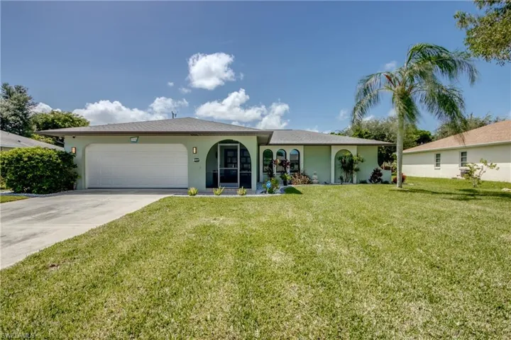 Ranch-style house with a garage and a front lawn