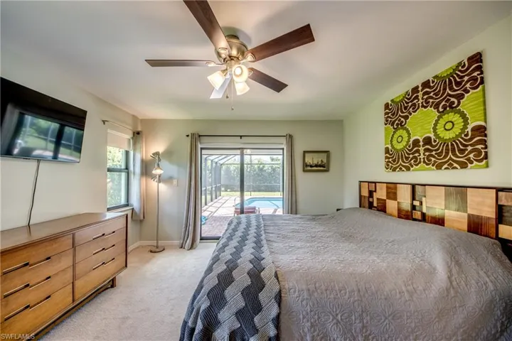 Carpeted bedroom featuring access to outside and ceiling fan