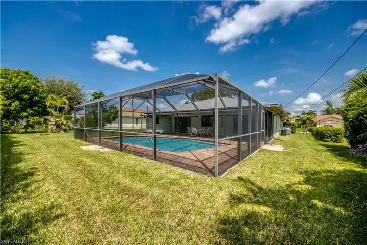 View of pool featuring a yard, a patio, and a lanai