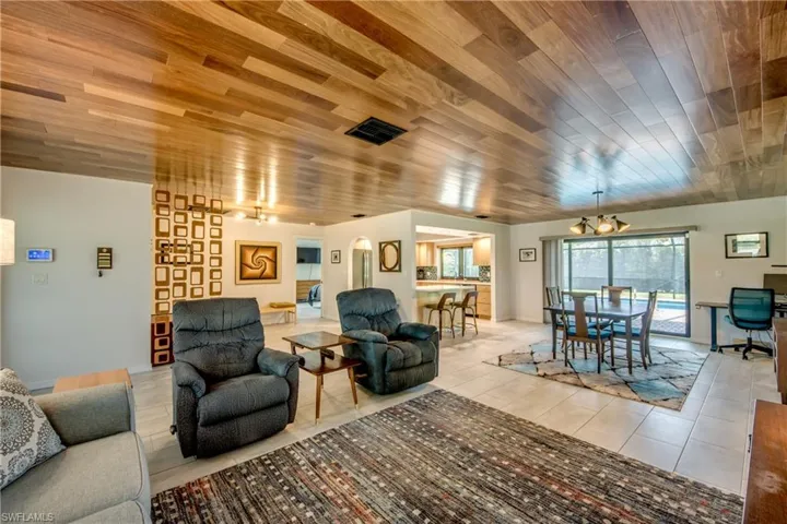 Living room featuring wooden ceiling, a chandelier, and light tile patterned floors
