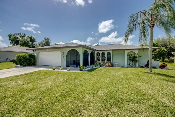 View of front facade featuring a garage and a front yard