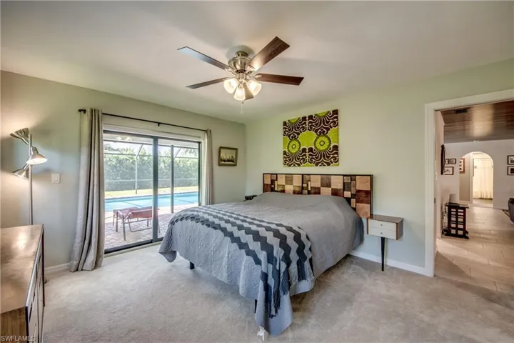 Bedroom with light colored carpet, access to outside, and ceiling fan