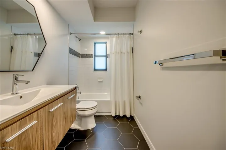 Full bathroom with vanity, toilet, shower / bath combination with curtain, and tile patterned flooring