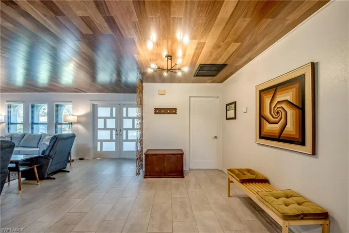 Entrance foyer featuring wood ceiling, a chandelier, and french doors