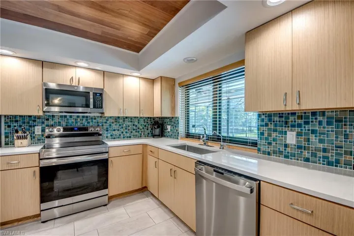 Kitchen featuring stainless steel appliances, sink, and light brown cabinets