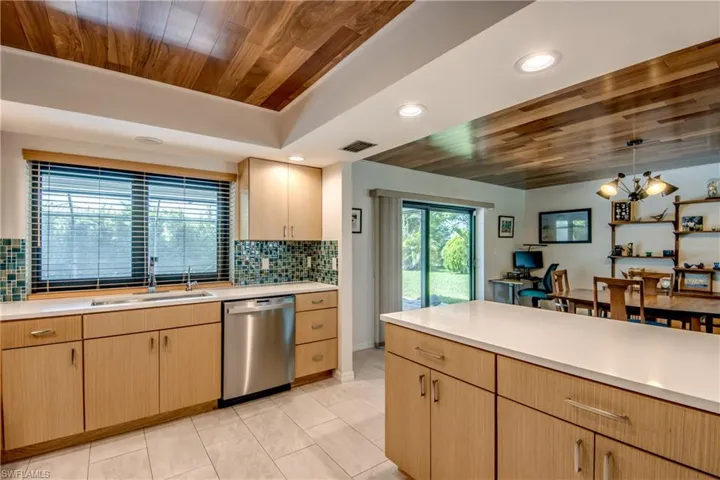 Kitchen featuring light brown cabinetry, wood ceiling, a notable chandelier, sink, and stainless steel dishwasher