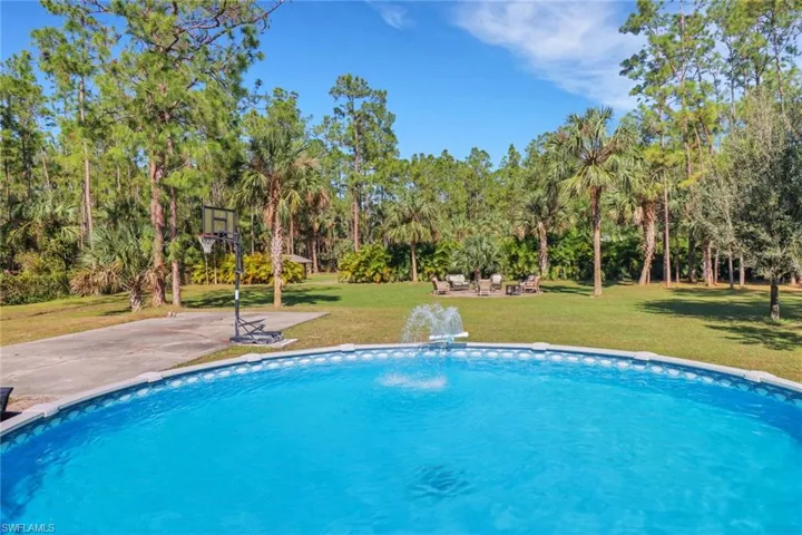 Another view from the pool of the large backyard with firepit area, basketball court, chicken coop, and large cleared area in the back to park your boats/rv/ or work trucks! Theres also a space that has been cleared and raised for a 40x60 workshop