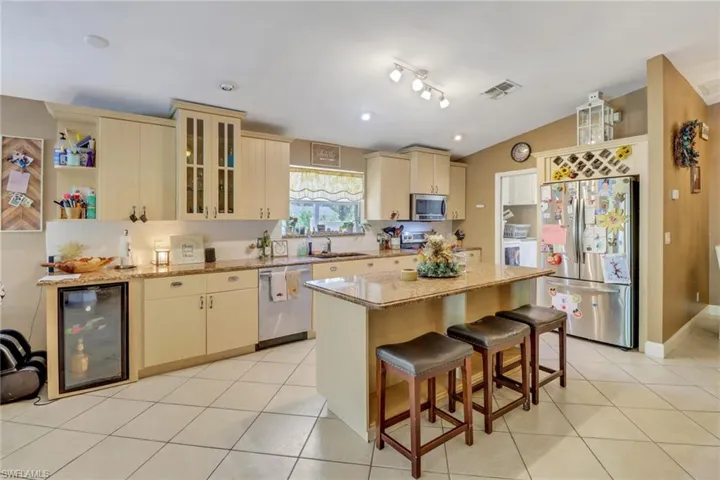 Bright and open kitchen with stainless steel appliances, ample cabinet/counter space, large pantry, wine rack, wine cooler.