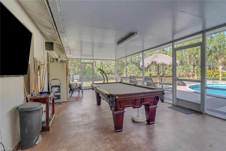 Another view of the large enclosed lanai (Great Space for gatherings) Nice view of the pool and large backyard that is fully cleared and 100% upland