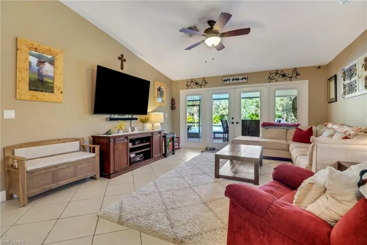 Spacious and bright living room that leads you to the enclosed lanai area and pool area/backyard.