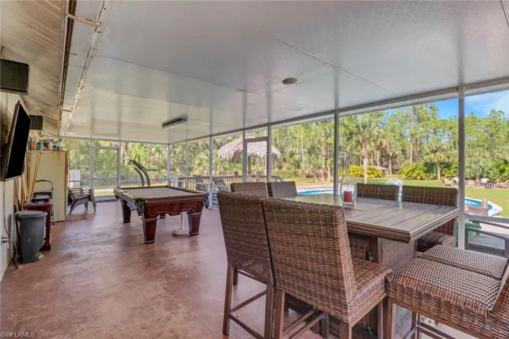 Large enclosed lanai with a view of the pool area and huge backyard that is fully cleared and 100% upland!