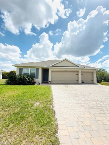 Ranch-style house featuring decorative driveway, a front yard, a garage, and stucco siding