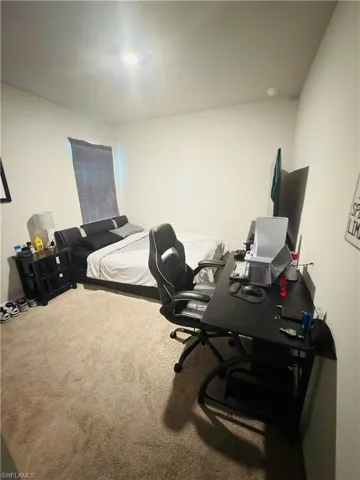 Carpeted bedroom with an office area