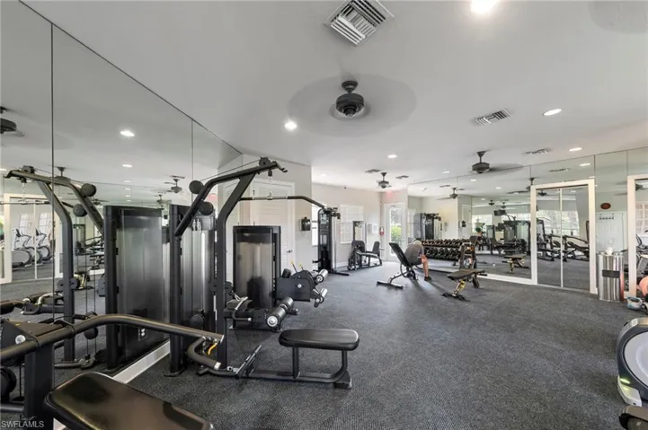 Fitness room featuring wall-to-wall mirrors, recessed lighting, ceiling fans, and durable flooring