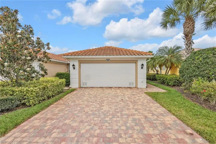 Mediterranean / spanish home with stucco siding, a tiled roof, and driveway