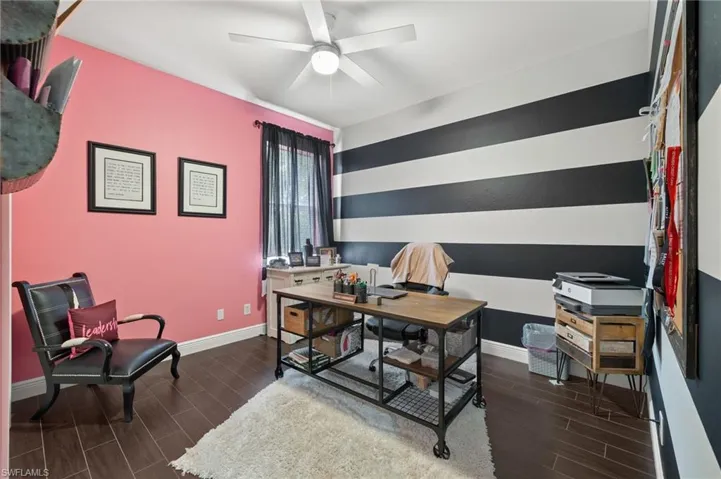 Home office with wood finish floors, an accent wall, and ceiling fan