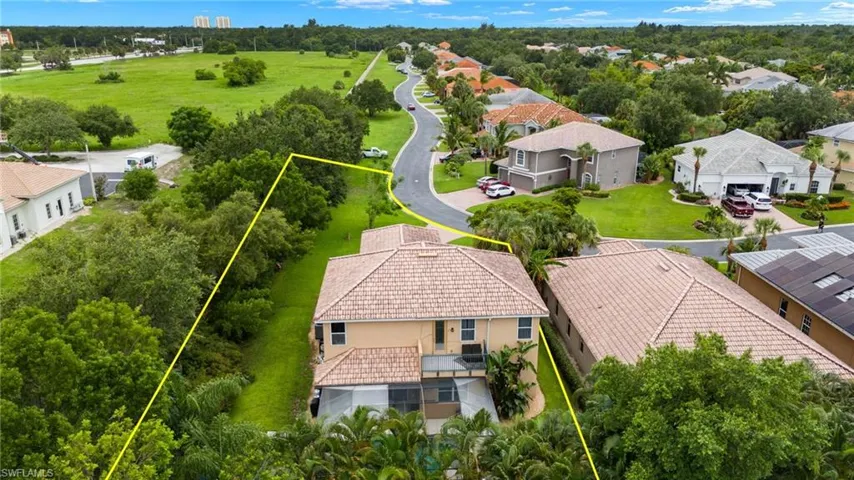 Aerial view of residential area with property boundaries highlighted and a tree filled landscape