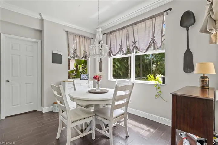 Dining room with wood finish floors, crown molding, and a chandelier