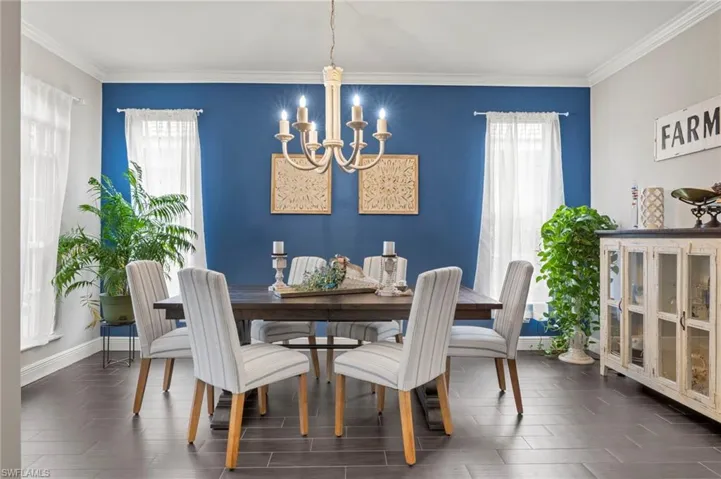 Dining area featuring crown molding, suspended lighting, and wood tiled floors