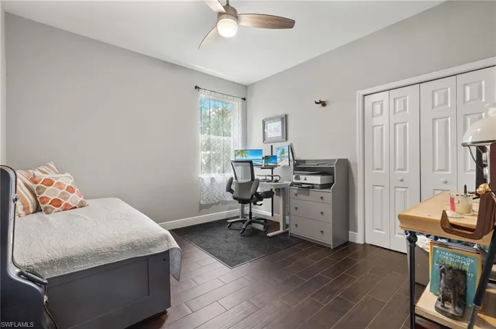 Bedroom with a desk, ceiling fan, a closet, and wood finish floors