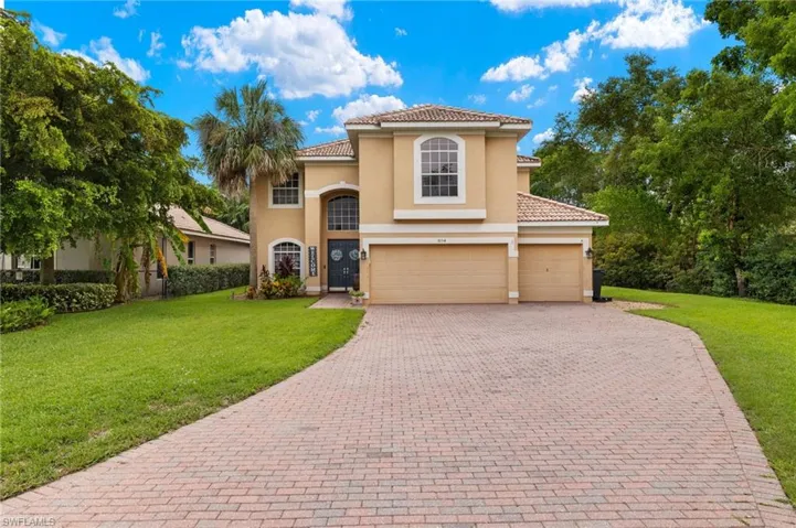 Mediterranean / spanish house featuring a front lawn, stucco siding, decorative driveway, and a tiled roof