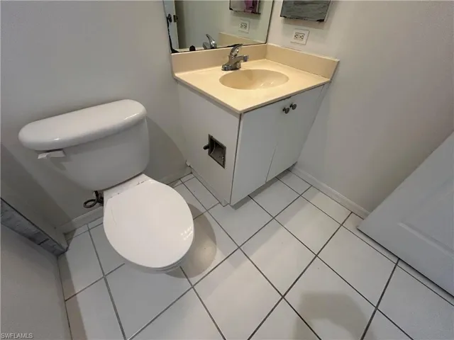 Half bathroom with vanity and light tile patterned floors