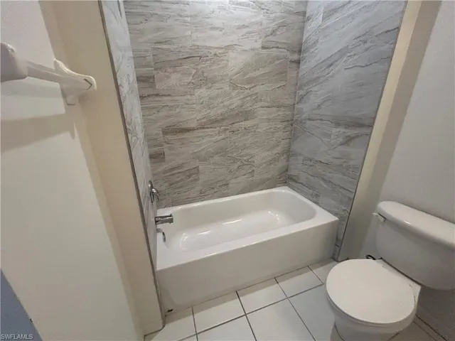 Full bath with  shower combination and light tile patterned flooring