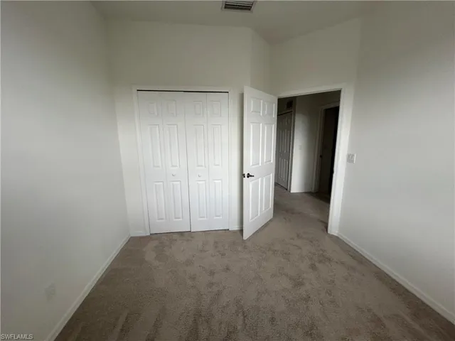 Unfurnished bedroom featuring carpet flooring and a closet