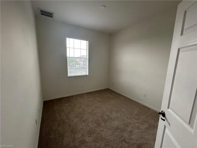 Spare room featuring carpet and baseboards