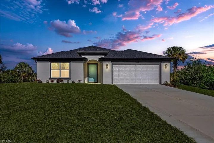 View of front of property featuring a lawn and a garage