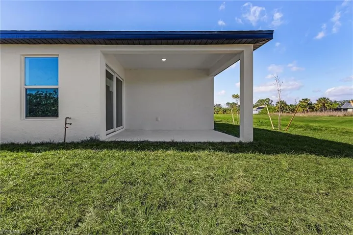Back of property with a yard and a patio