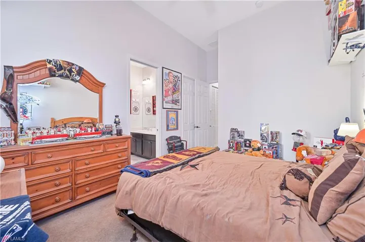 Bedroom featuring light carpet, a closet, and ensuite bathroom