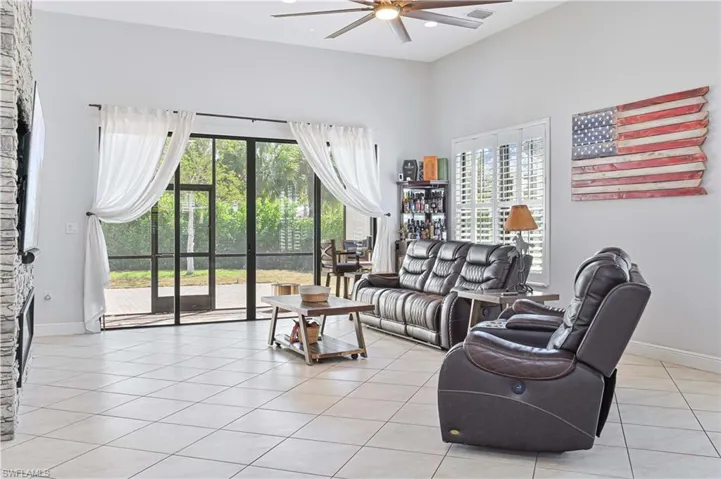 Living area featuring a ceiling fan and light tile patterned floors