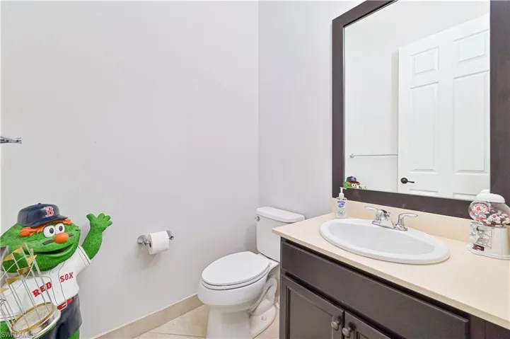 Half bathroom with vanity and light tile patterned floors