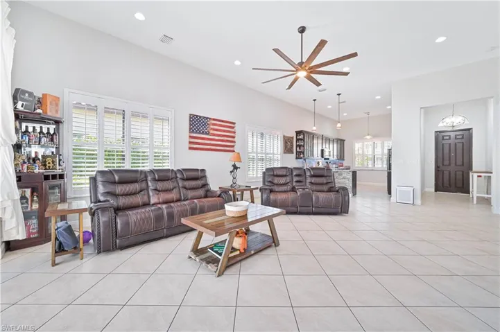 Living room with light tile patterned flooring, ceiling fan, and recessed lighting