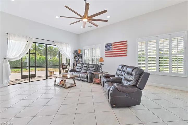 Living room with ceiling fan, light tile patterned floors, and recessed lighting