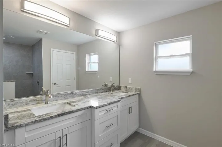 Bathroom with wood-type flooring, oversized vanity, and double sink