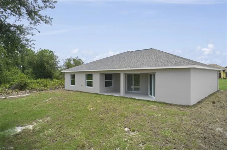 Back of property featuring a lawn