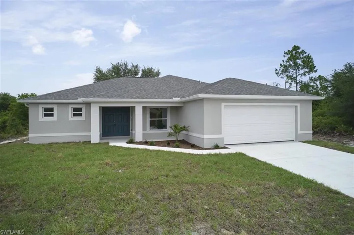 View of front of home with a garage and a front lawn