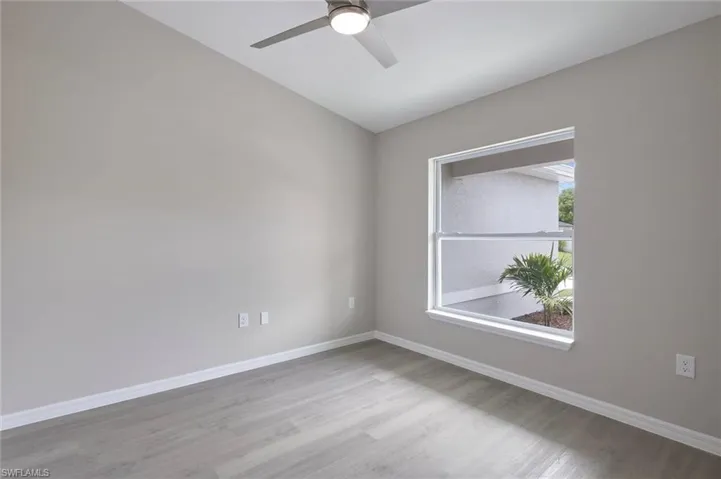 Empty room with ceiling fan and light hardwood / wood-style flooring