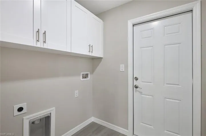 Laundry room featuring electric dryer hookup, wood-type flooring, cabinets, and hookup for a washing machine