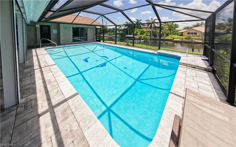 View of swimming pool featuring a water view, a patio area, and a lanai