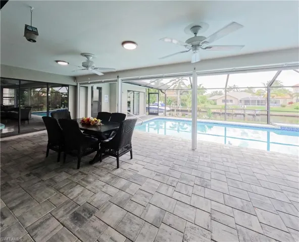 View of swimming pool featuring ceiling fan