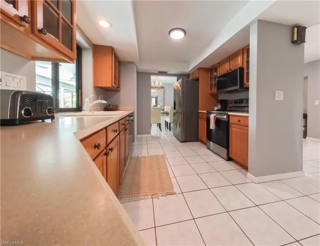 Kitchen featuring sink, appliances with stainless steel finishes, and light tile patterned floors
