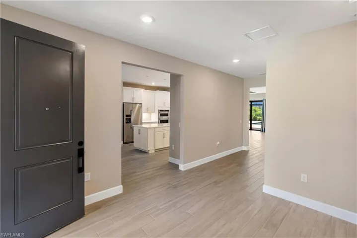 Entrance foyer with light wood-style tile floors and recessed lighting