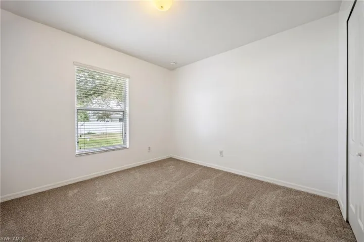 Empty room featuring carpet flooring and baseboards