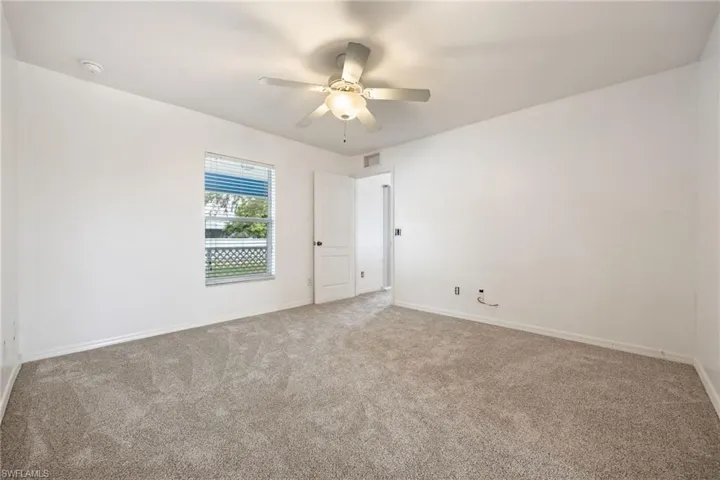Unfurnished room featuring carpet floors and ceiling fan