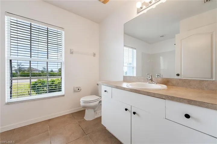 Bathroom featuring vanity, light tile patterned floors, and a shower